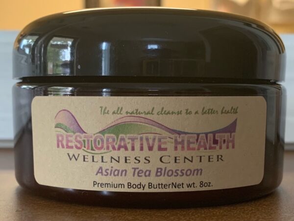 A jar of asian tea blossom on a table.